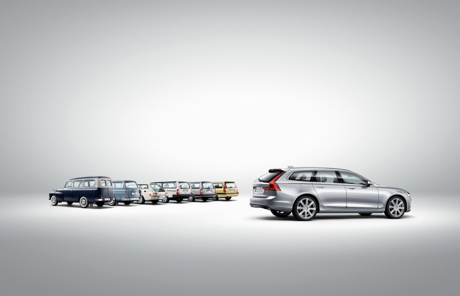 A profile view of a silver Volvo V90 with several older Volvo wagon models.