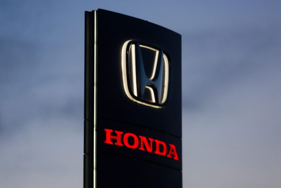 A black Honda dealership sign with Honda written in red underneath.