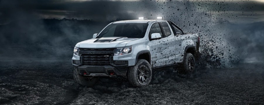 A white 2022 Chevy Colorado spraying dirt.