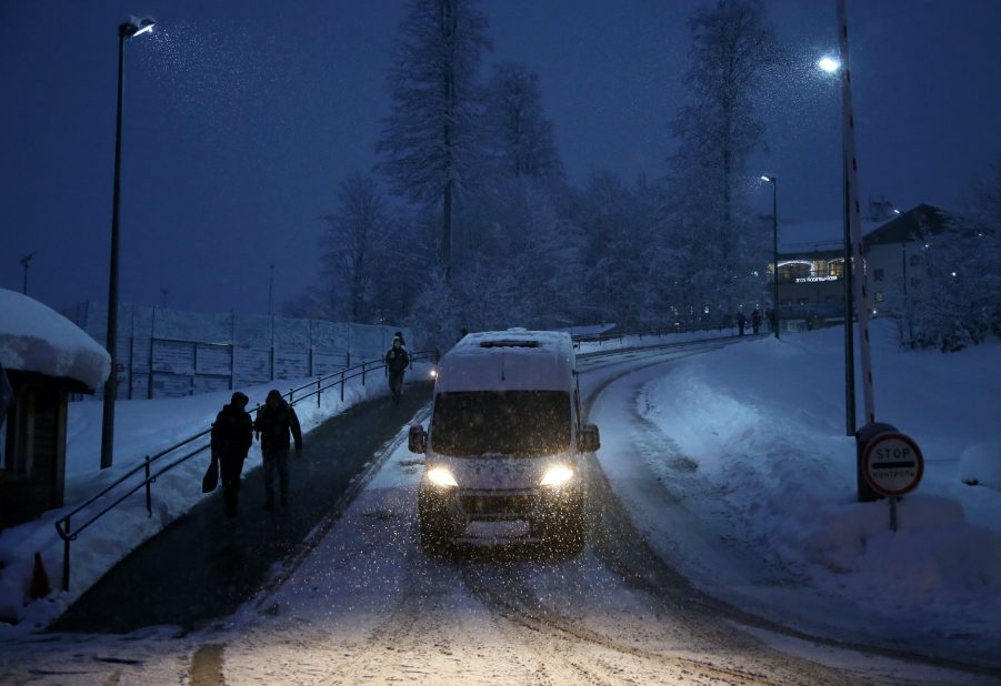 A van drives through winter weather in a snow storm