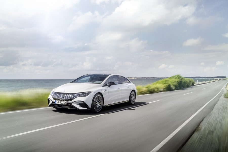 A white 2023 Mercedes-AMG EQE drives down a road