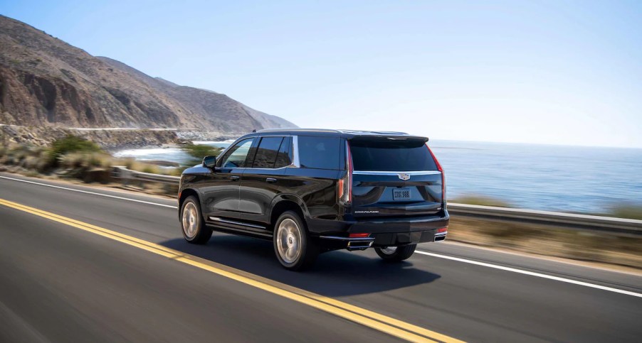 The Cadillac Escalade cruises near a coast.