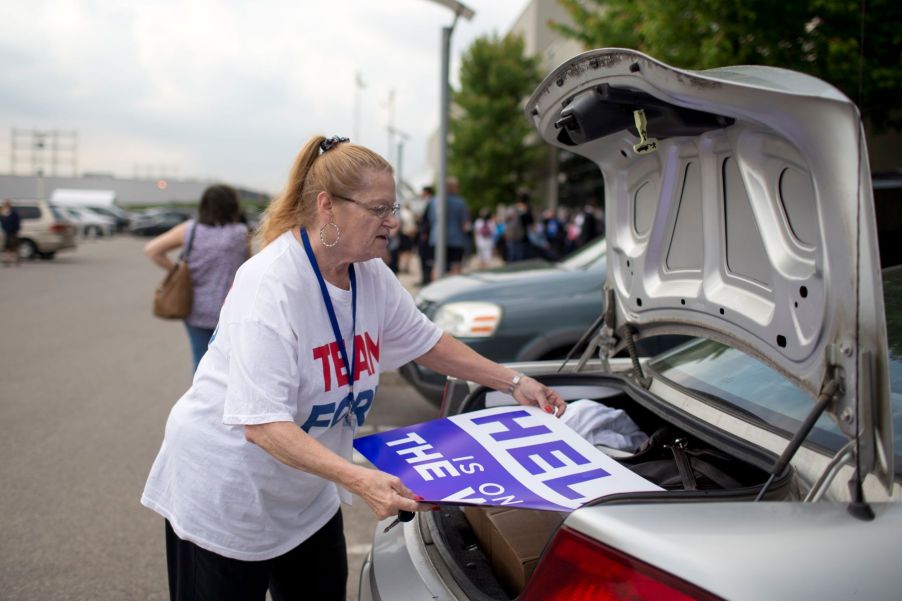 A Candian woman opening trunk and removing signs at the Toronto Congress Centre