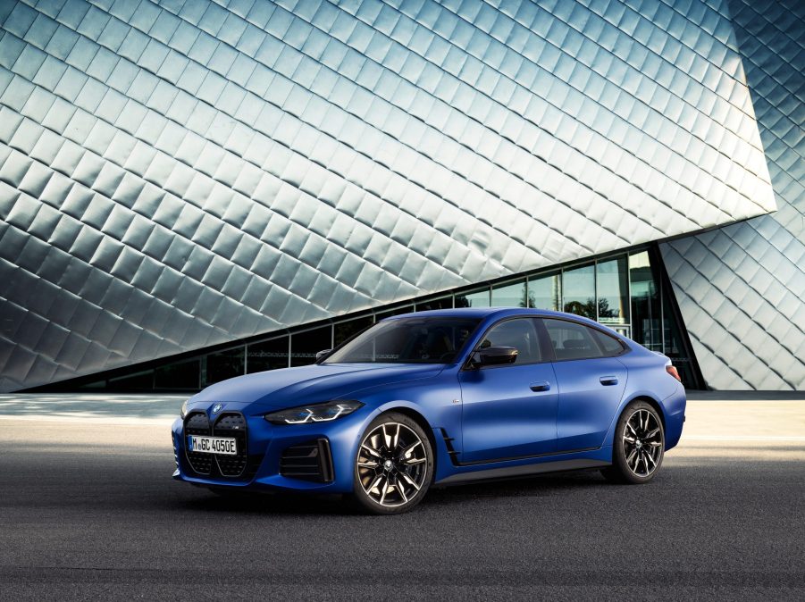 A 3/4 front view of a blue 2022 BMW i4 M50 sedan in front of a silver building.