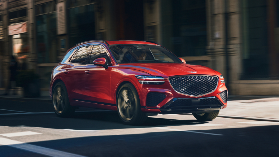 Red 2022 Genesis GV70 driving on a street, highlighting how Genesis has good warranty coverage