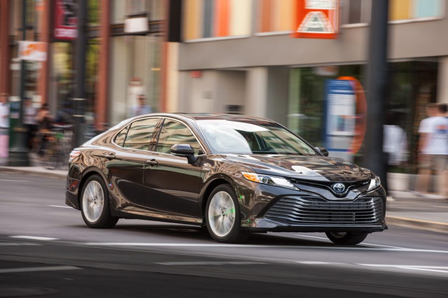 Moving shot of a 2019 Toyota Camry sedan driving in a city