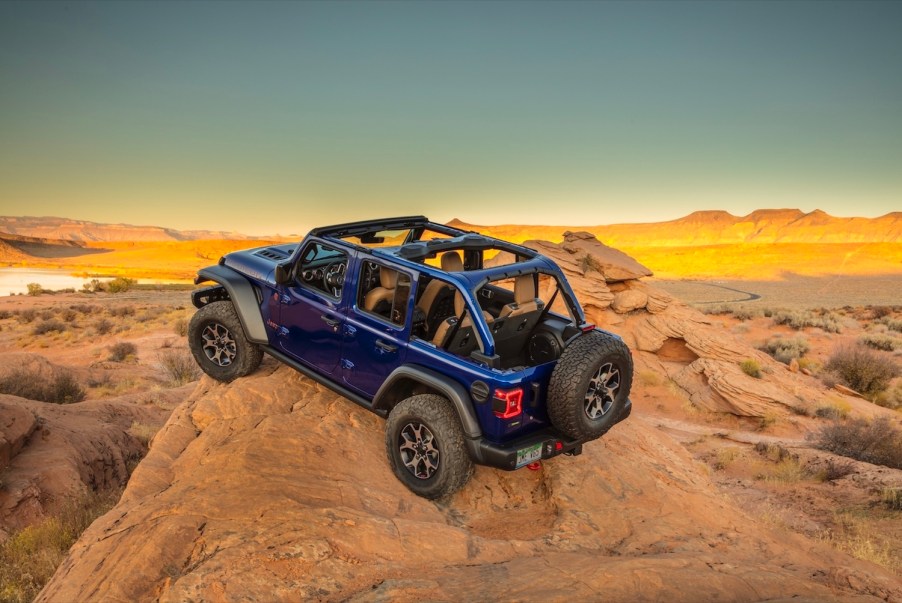 Purple Jeep Wrangler 4x4 SUV parked on a mountaintop.