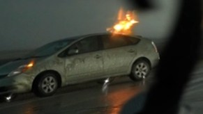 Close-up view of silver Toyota Prius struck by a bolt of lightning