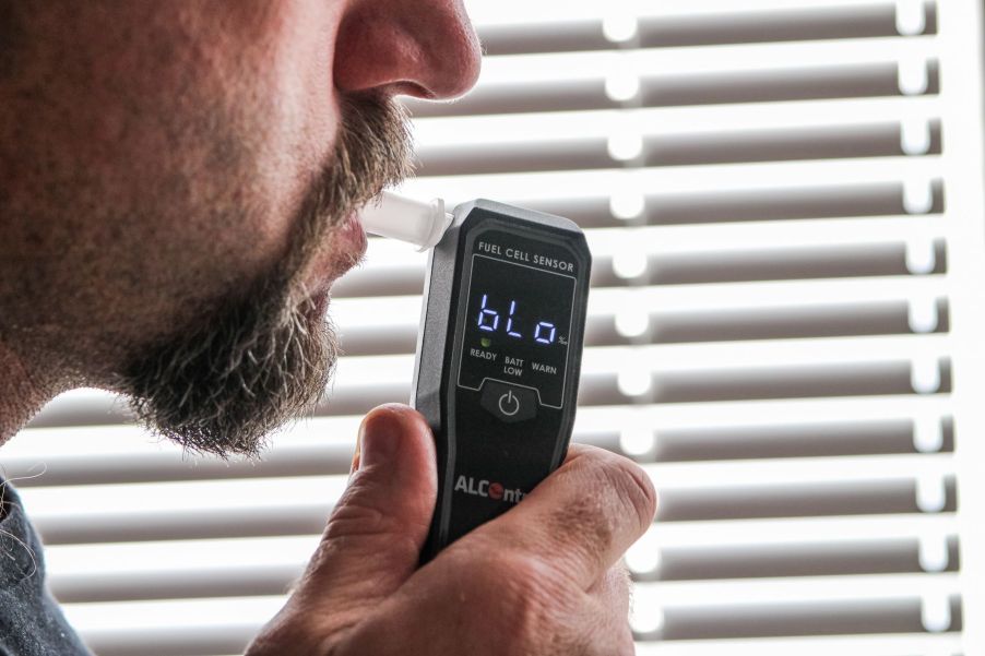 A man suspected of drinking and driving takes a breathalyzer test