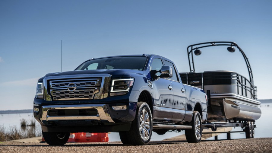 Heavy-duty Nissan Titan XD pickup truck towing a pontoon boat.