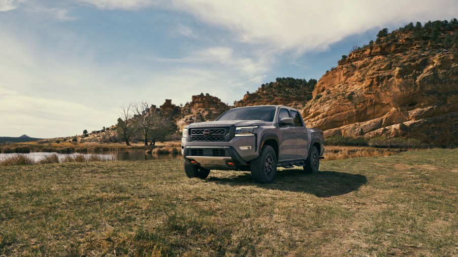 A 2022 Nissan Frontier sits in front of some rugged terrain. Showing off its capability as a mid-size truck.