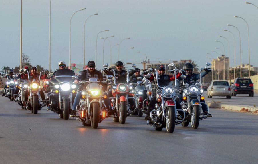 A crowd of motorcycle riders driving down the road.