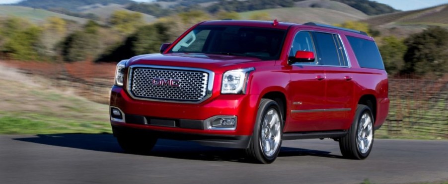 A red 2017 GMC Yukon driving outside.