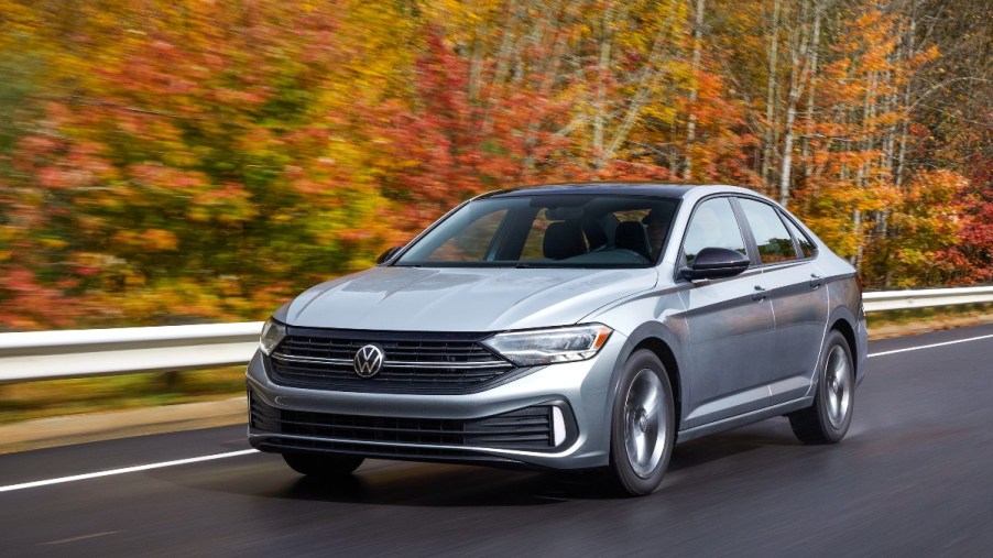 a silver 2022 volkswagen jetta driving on a road