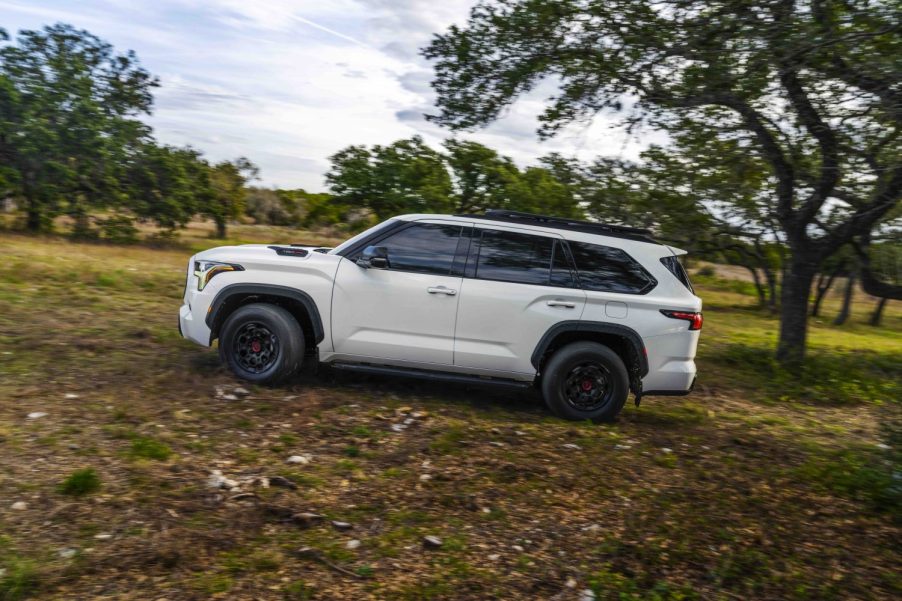 White Toyota Sequoia 4x4 SUV off-roading through the woods.