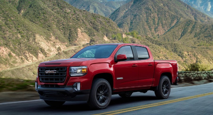 A red 2022 GMC Canyon is driving on the road.