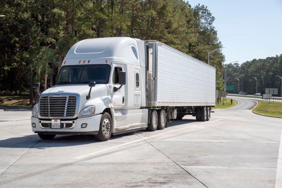 A white semi trucker potentially having a place where truck drivers sleep.