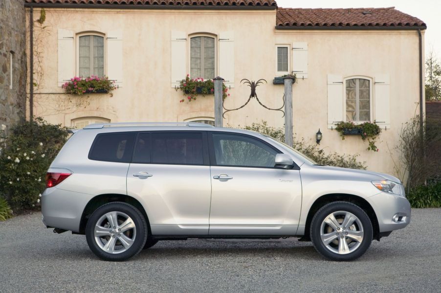 2008-2010 generation of the Toyota Highlander midsize SUV side shot next to a villa