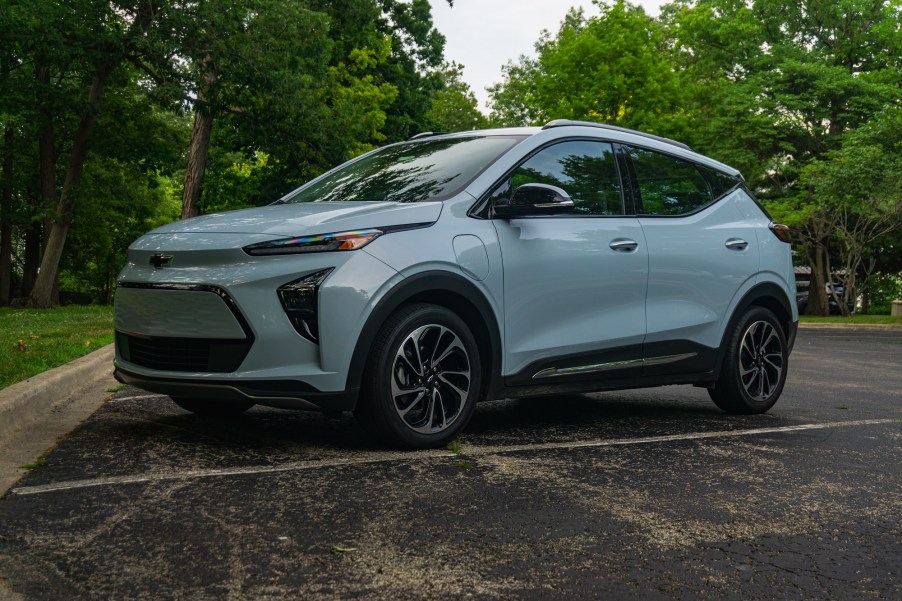 A light-blue 2022 Chevrolet Bolt EUV Premier in a forest parking lot