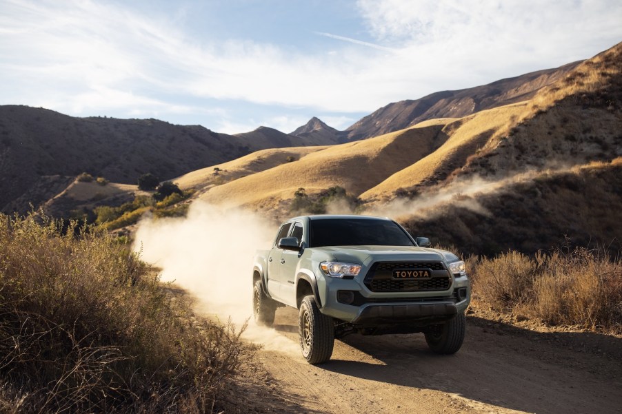 A 2022 Toyota Tacoma midsize truck driving in the dirt