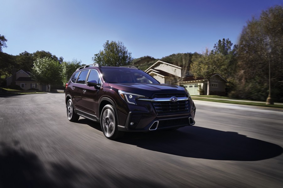 A dark red 2022 Subaru Ascent driving down a winding road.