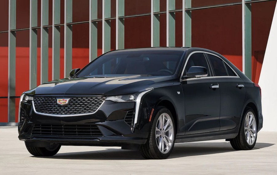 A black 2023 Cadillac CT4 Luxury 350T in front of a red-and-white building