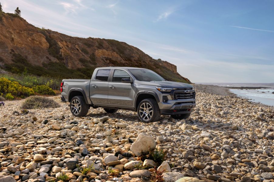 A 2023 Chevrolet Colorado Z71 midsize pickup truck parked on a beachfront covered in rocks