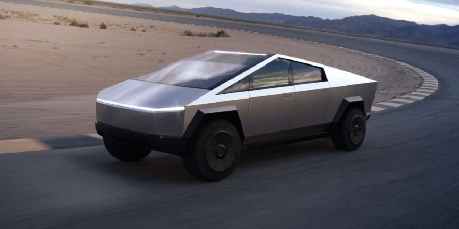 A silver Tesla Cybertruck driving around a test track.