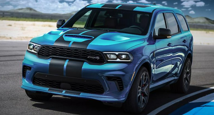 A blue Dodge Durango SRT Hellcat is driving on a track.