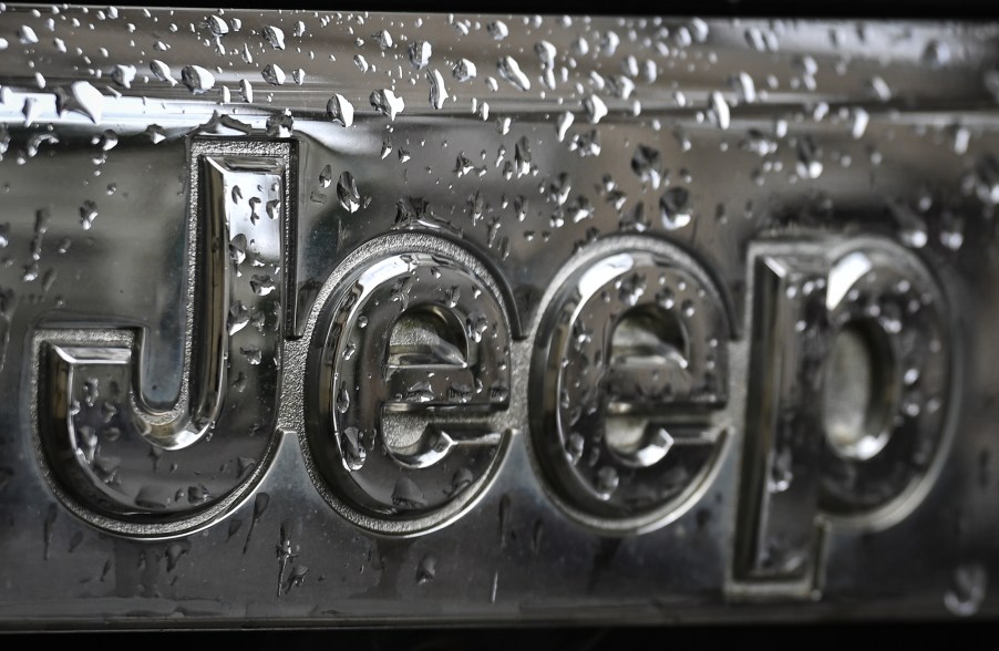 A silver Jeep logo covered in water, maker of the Jeep Wrangler.