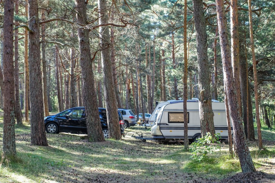 Good camper trailers pulled by SUVs in the forest.