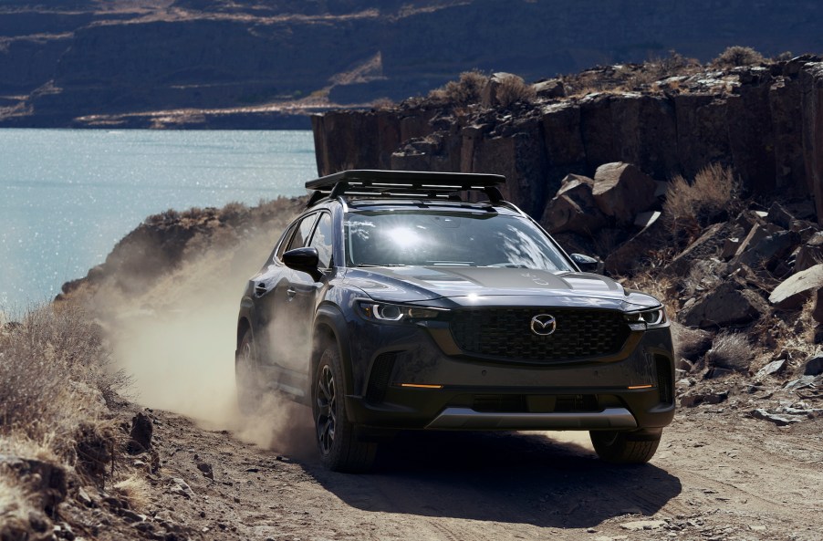 A Mazda CX-50 safety features at work while driving on a dirt road.