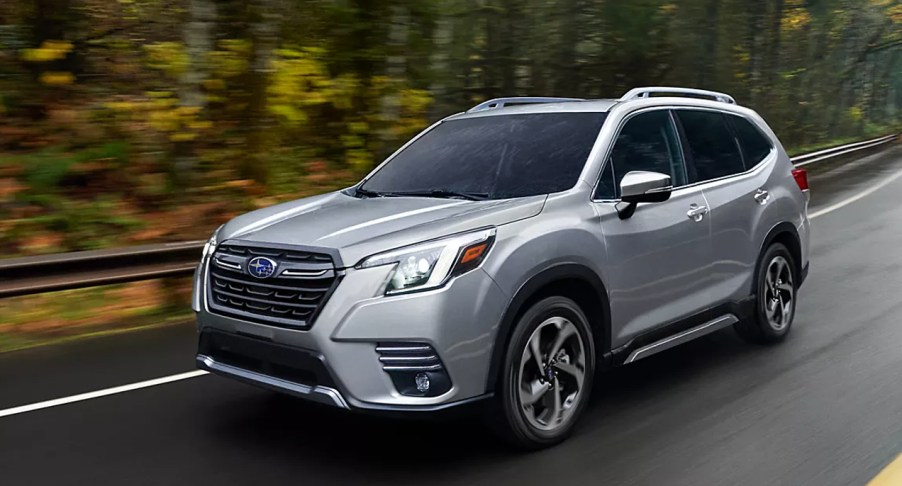 A gray Subaru Forester small SUV is driving on the road.