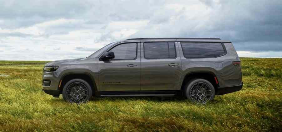 A gray 2023 Jeep Wagoneer L parked in a field. The longer wheelbase is one reason it's worth waiting for.