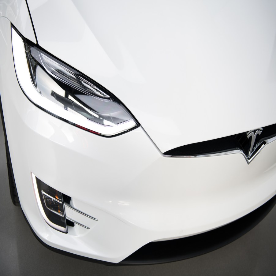 An EV turning signal and headlight, which the turn signals affect an EV's driving range, on a white Tesla.