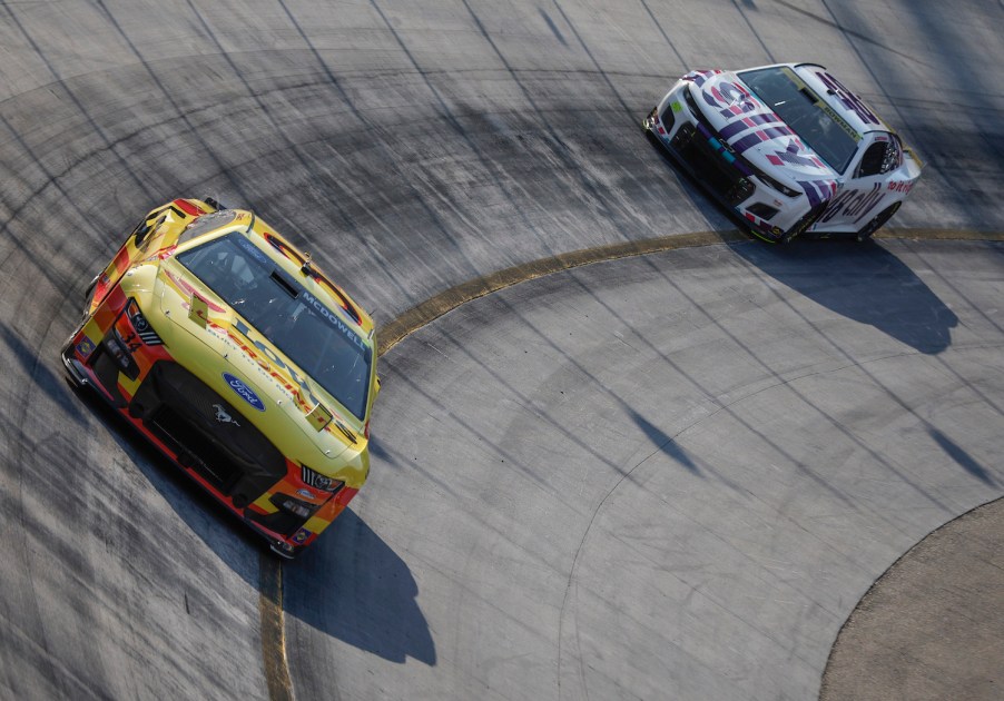 Two NASCAR Cup Cars completing practice laps at Bristol Motor Speedway before a race.