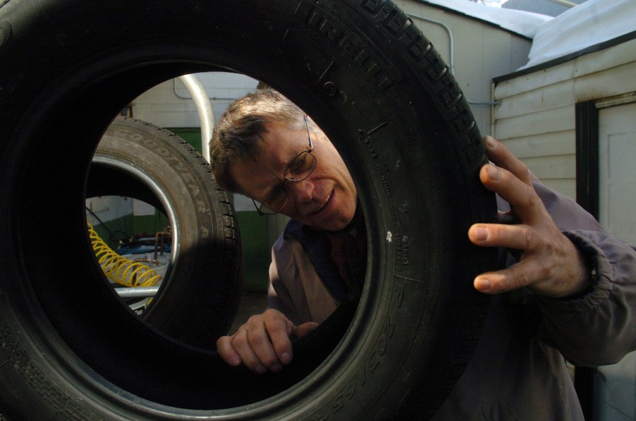 A person looking at the tire's sidewall.