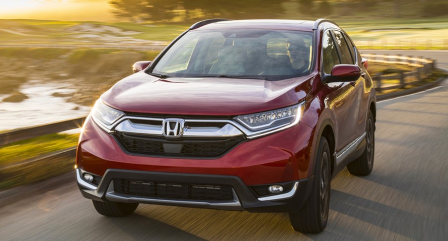 A red 2019 Honda CR-V is driving on the road.