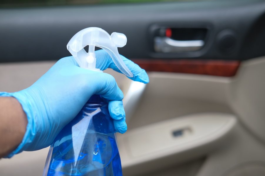 A person using car cleaning to clean the interior of their car