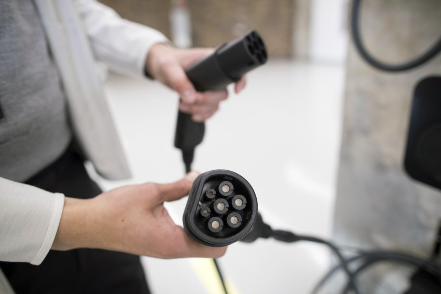 A person holding an EV charger.