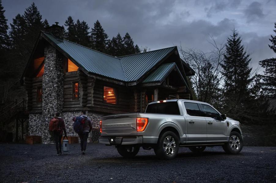 Silver 2023 Ford F-150 pickup truck, most popular car for wealthy people, parked near a cabin