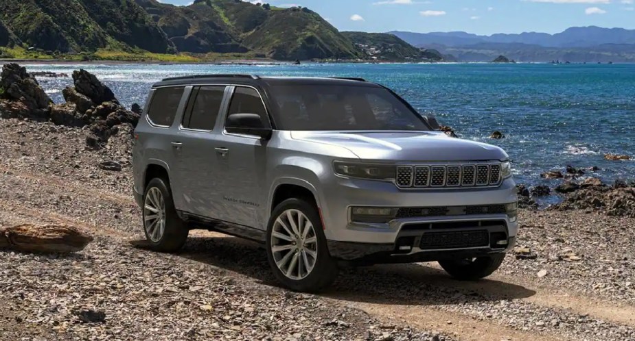 A gray 2023 Jeep Grand Wagoneer large luxury SUV is parked off-road. 