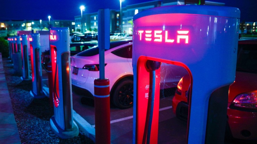 Electric cars at Tesla charging station, highlighting how EVs reduce gas usage in America less than expected