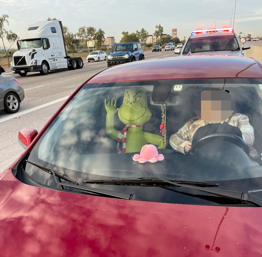 an inflatable grinch holiday decoration rides in the passenger seat of an Arizona man's vehicle