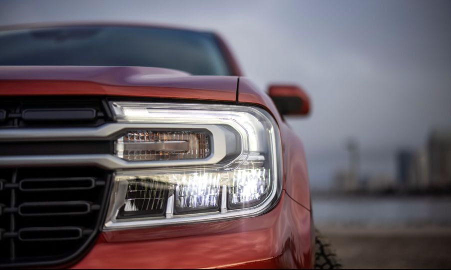 A closeup on the grille and headlights of a red 2022 Ford Maverick Lariat compact pickup truck model