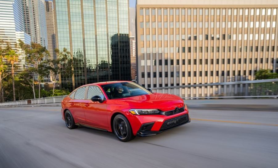 A post-facelift Honda Civic compact car from 2022 or 2023 drives on city streets.