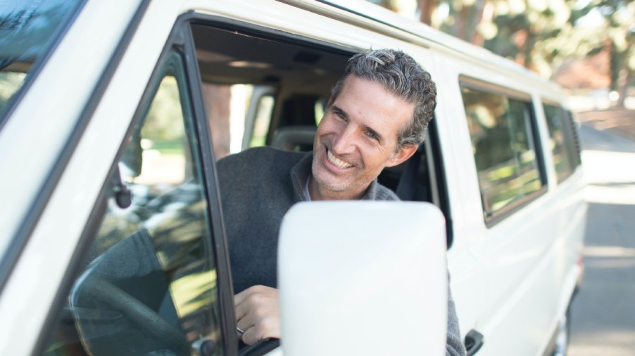 Man sticks head out the window of a van, highlighting whether driving a car makes you smarter or dumber