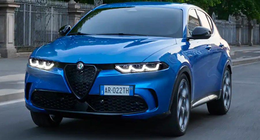 A blue 2023 Alfa Romeo Tonale subcompact plug-in hybrid luxury SUV is driving on the road.