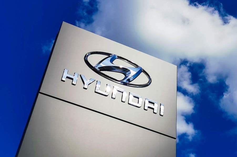 A Hyundai Motor Group logo on a sign. Compare the Hyundai annual maintenance costs, including the 90s Hyundai Scoupe.