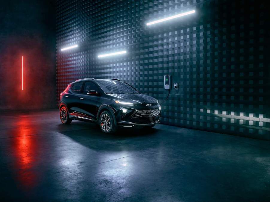 A dark color 2023 Chevrolet Bolt, which is one of the best Chevrolet SUVs, in a dark room lit with long bulbs.